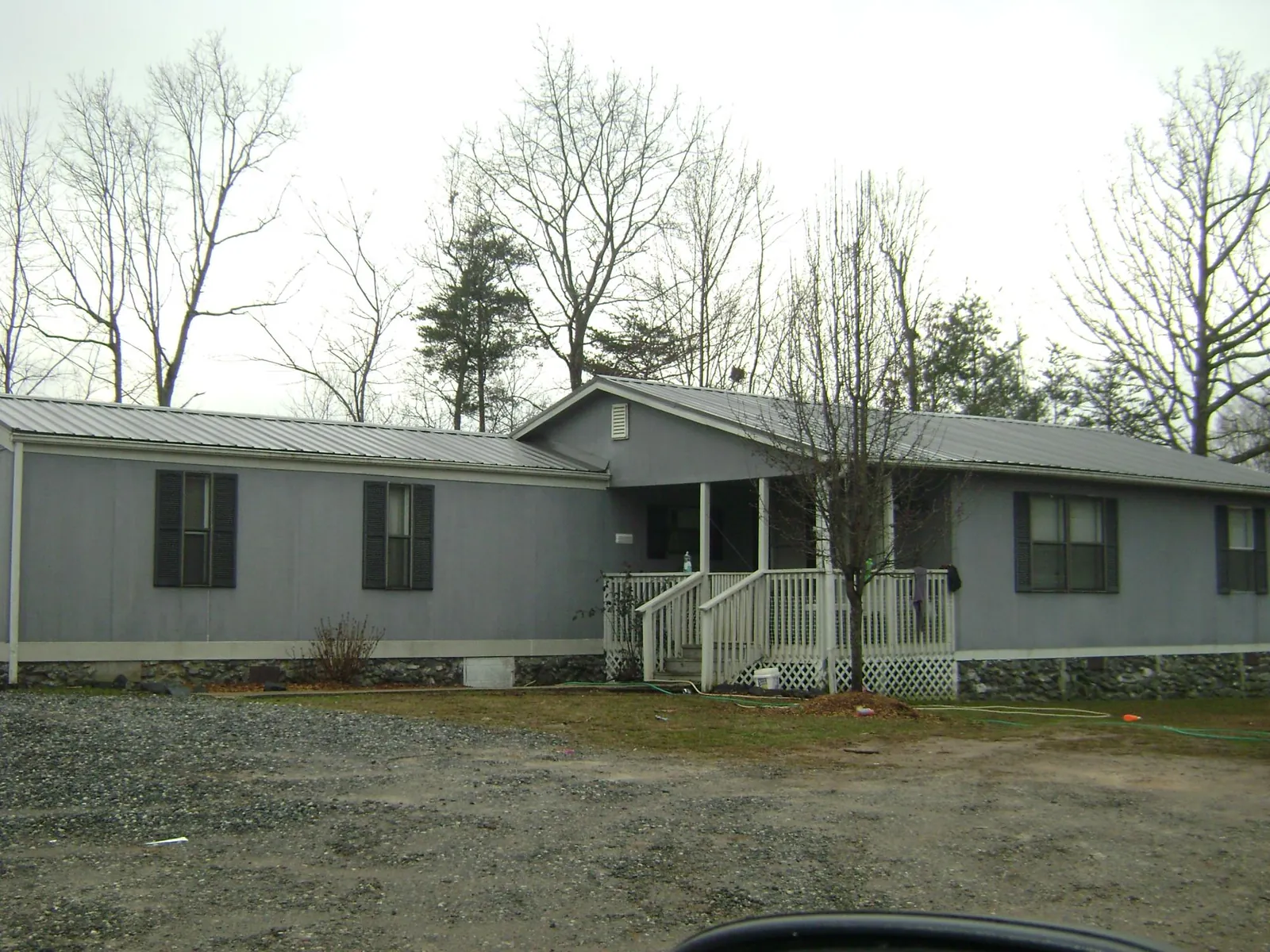 Metal roof over a manufactured home with a covered front porch in Schwertner